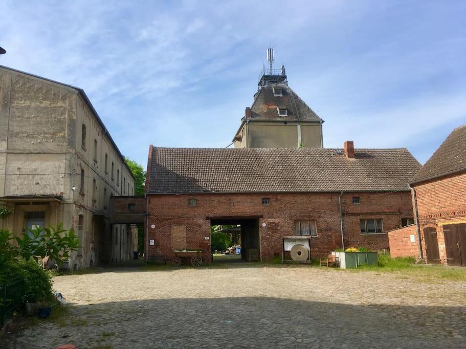 an old brick building with a tower on top of it at Bensdorfer Mühle - Auszeit in Brandenburg in Bensdorf