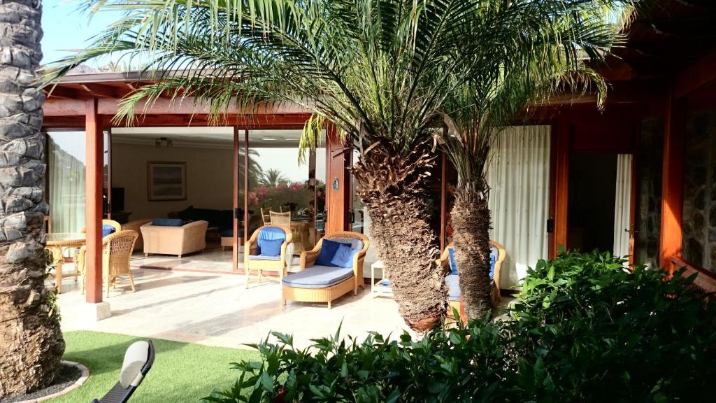 patio z palmami i krzesłami na domu w obiekcie Villa Luxe Tauro Mogan w mieście Puerto Rico de Gran Canaria