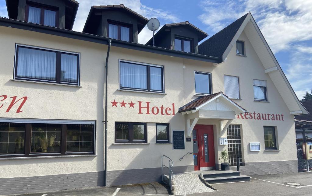 un hôtel avec une porte rouge dans une rue dans l'établissement Landgasthaus Zollerstuben, à Bermatingen