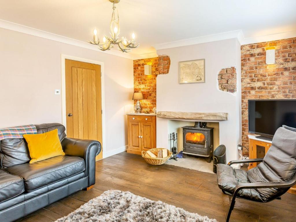 a living room with a couch and a fireplace at Church View in Barmby on the Marsh