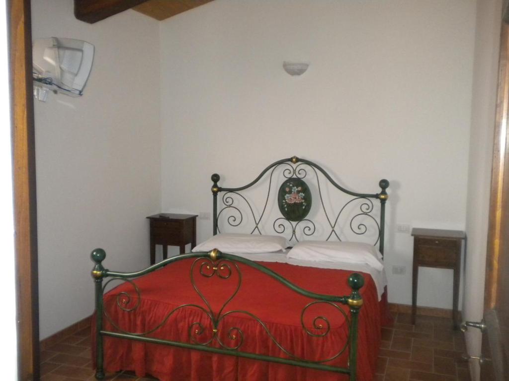 ein Bett in einem Zimmer mit einer roten Decke darauf in der Unterkunft Monte Fugnano in Gubbio