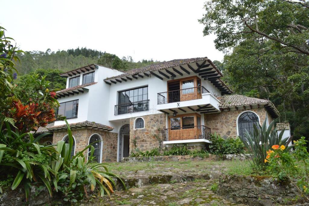 a house in the middle of a garden at Hermosa casona sobre la represa la Esmeralda in Somondoco