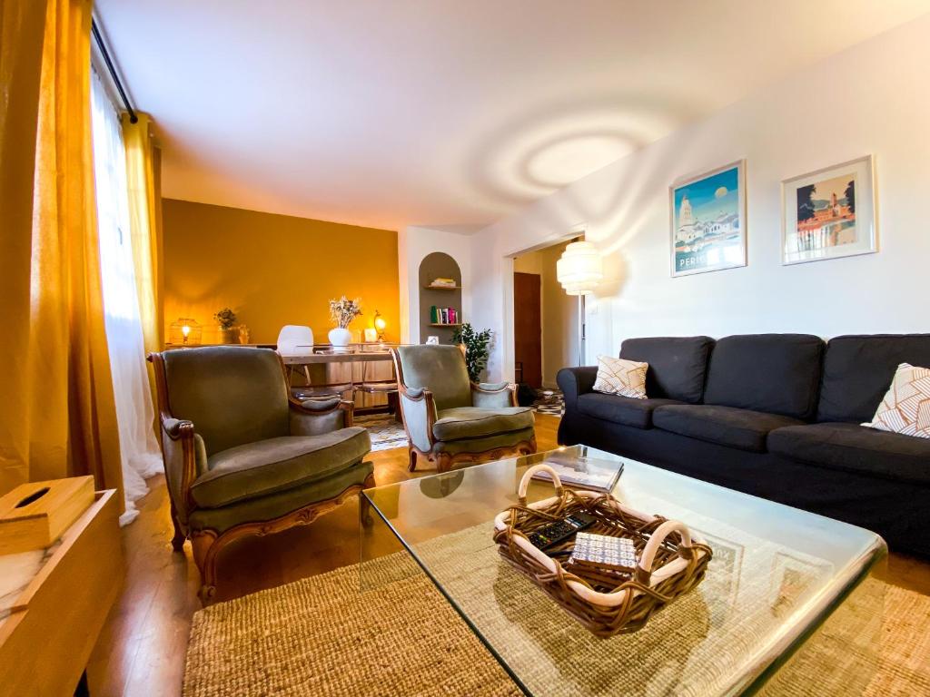 a living room with a couch and chairs and a table at Appartement avec vue sur la tour de Vésone in Périgueux