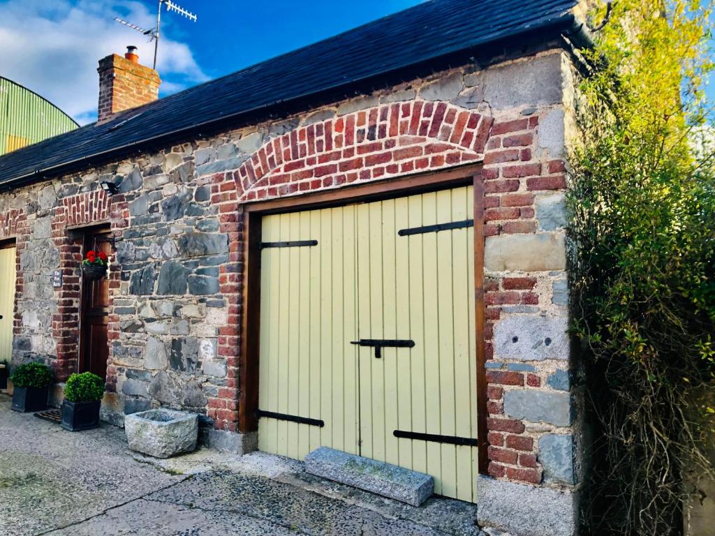 a brick building with two garage doors on it at The Wee Barn. In the heart of the countryside in Corbet Milltown