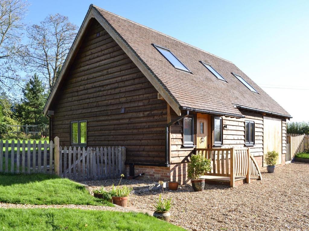 a small wooden house with a fence in front of it at Boreham Bridge Barn in Ashburnham