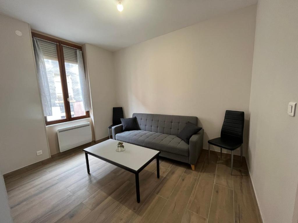 a living room with a couch and a table at Appartement rénové à 15min de Lyon in Saint-Fons