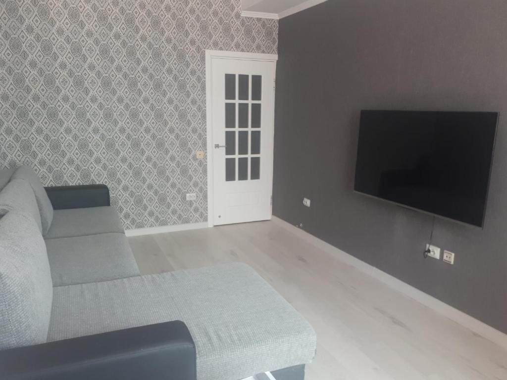 a living room with a couch and a flat screen tv at Уютные апартаменты 5 микрорайон in Aktau