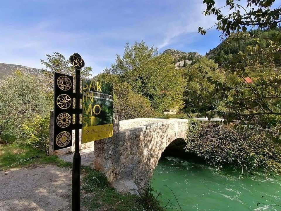 uma ponte sobre um rio com uma placa ao lado em Holiday Home Sarin Most em Stolac