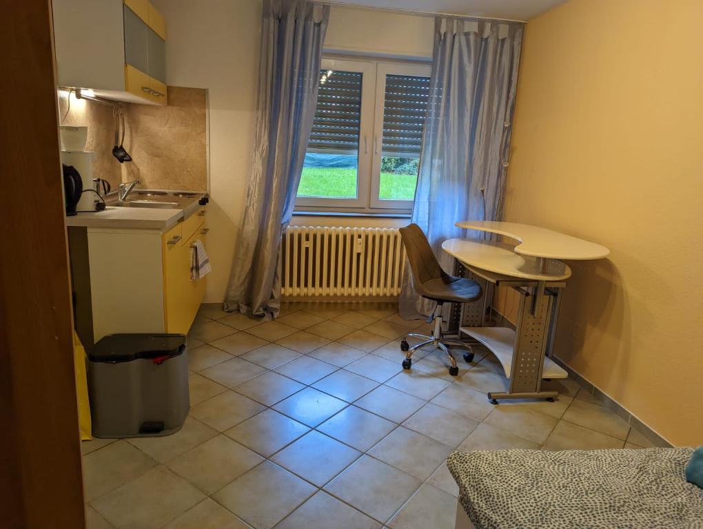 una pequeña cocina con mesa, sillas y fregadero en L8 Street Ladenburg Mannheim - Mitarbeiterwohnung zum Bestpreis finden, en Ladenburg