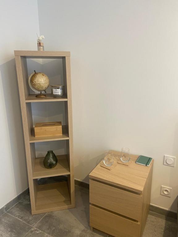 un estante de libros y una mesa en una habitación en Maison Climatisée proche du lac de Freminville, en Tignieu-Jameyzieu