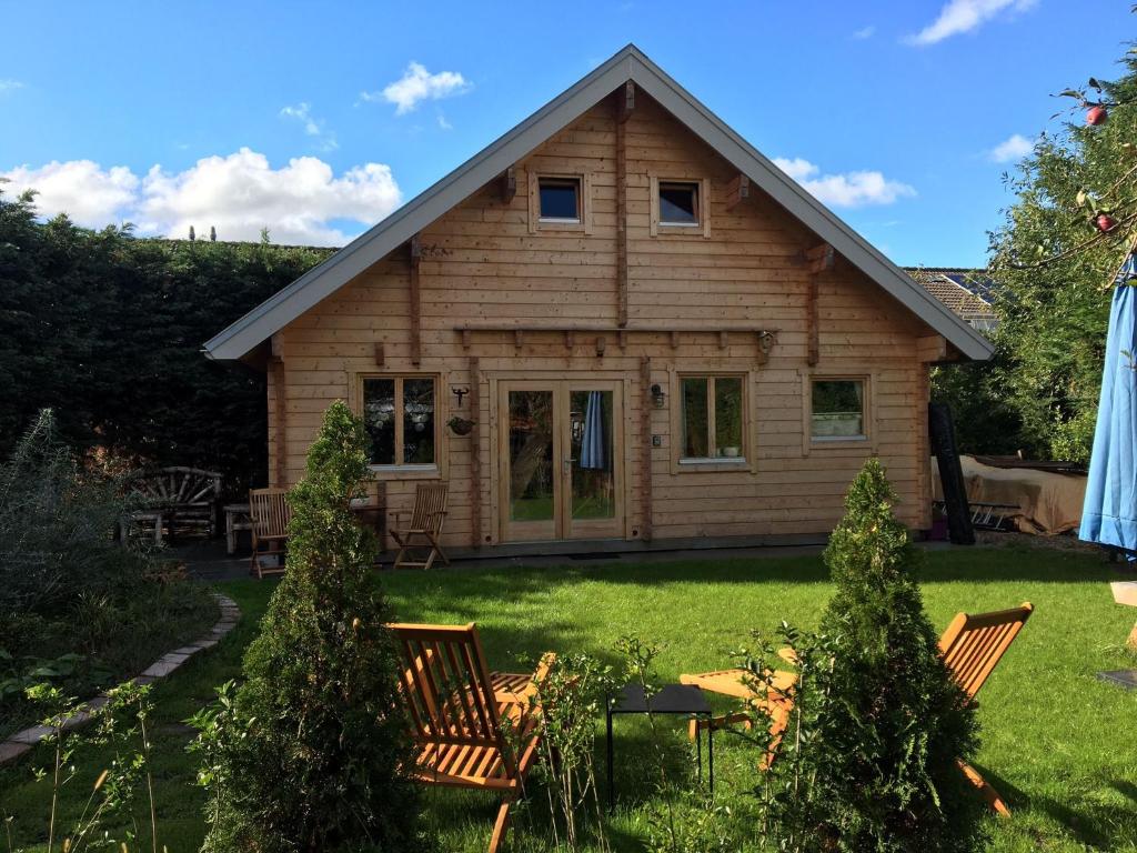 una casa con un patio con sillas y árboles en Chalet Ons Oekje en Vrouwenpolder