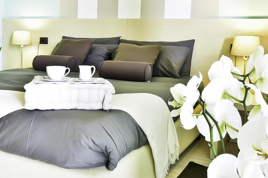 a room with a bed with a table and white flowers at B&B Calligaris in Dobrovo