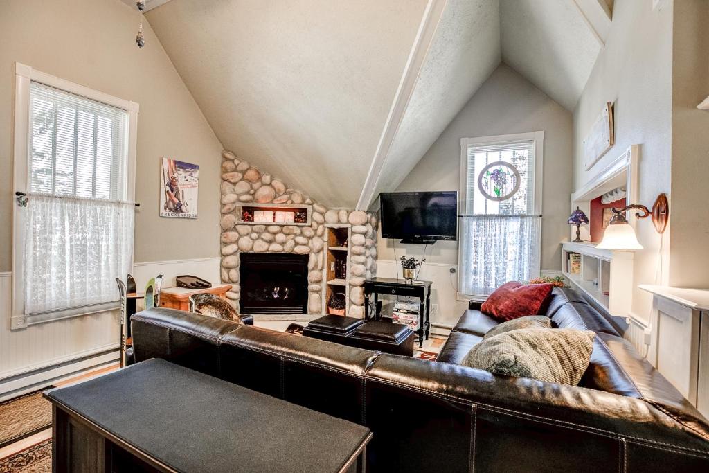 a living room with a leather couch and a fireplace at Brittany Place Condo - Great Downtown Location - On Main St in Breckenridge