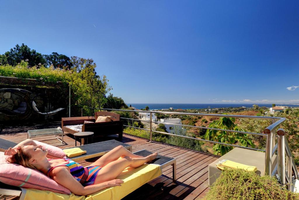 a woman laying on a couch on a deck at Marbella Boutique Art suites in Marbella