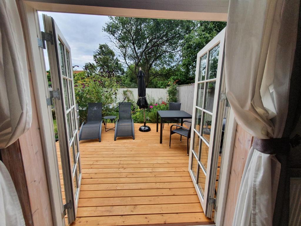 uma porta aberta para um pátio com uma mesa e cadeiras em BoWell apartments with terrace i Rønne em Rønne