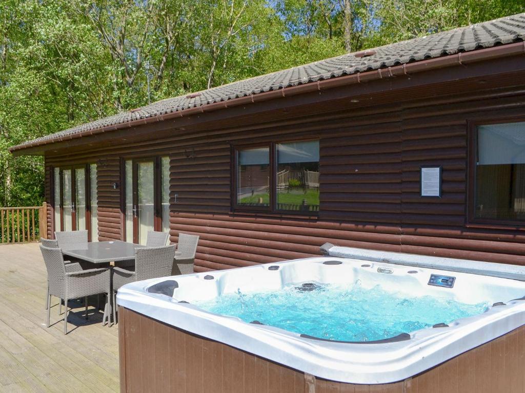 una gran bañera de hidromasaje en la cubierta de una casa en Leafy Run, en Otterburn