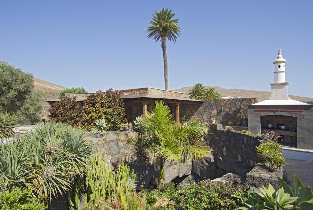 a building with a palm tree and a lighthouse at Villa Remedios in Teguise