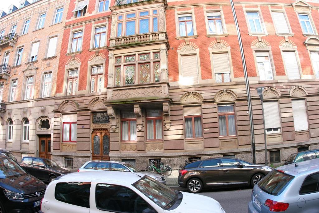 a large building with cars parked in front of it at Appartement Le Sleidan in Strasbourg