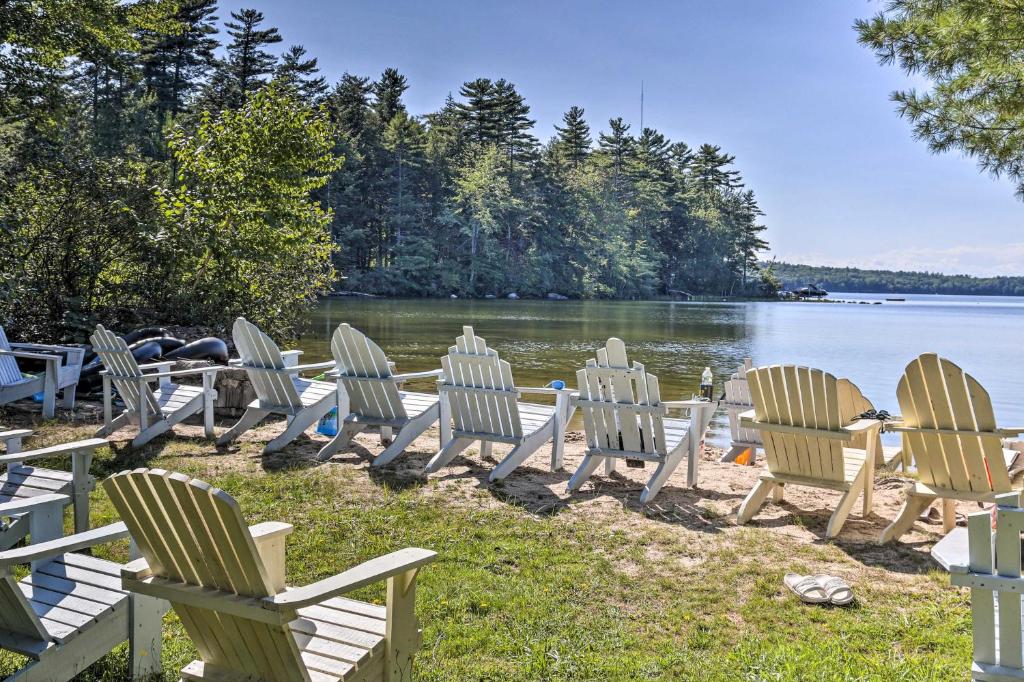 a row of chairs sitting on the shore of a lake at Raymond Retreat with 200 Feet of Private Beach! in Raymond