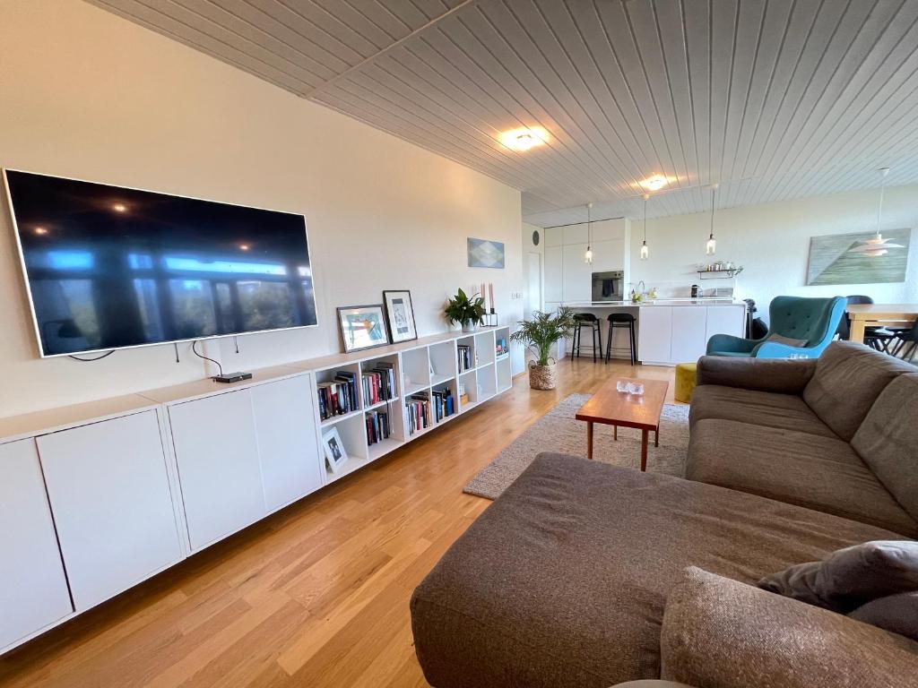 ein Wohnzimmer mit einem großen Flachbild-TV an der Wand in der Unterkunft Cosy and spacious apartment in Reykjavik in Reykjavík