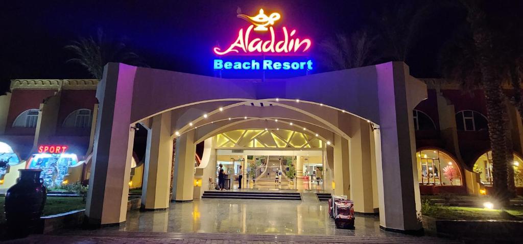 uma entrada para um resort de praia com uma placa de néon em Aladdin Beach Resort - Families and Couples Only em Hurghada