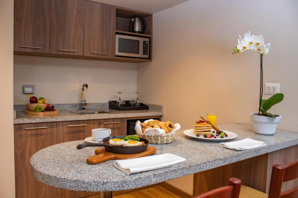 una cocina con una mesa con comida. en Estelar Apartamentos Bellavista, en Lima