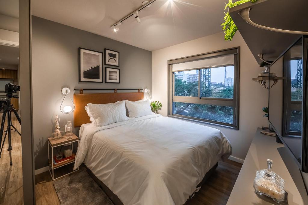 a bedroom with a large bed and a window at Noon Vila Madalena in Sao Paulo