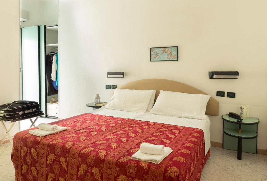 a bedroom with a bed with two towels on it at Hotel Stockholm in Rimini