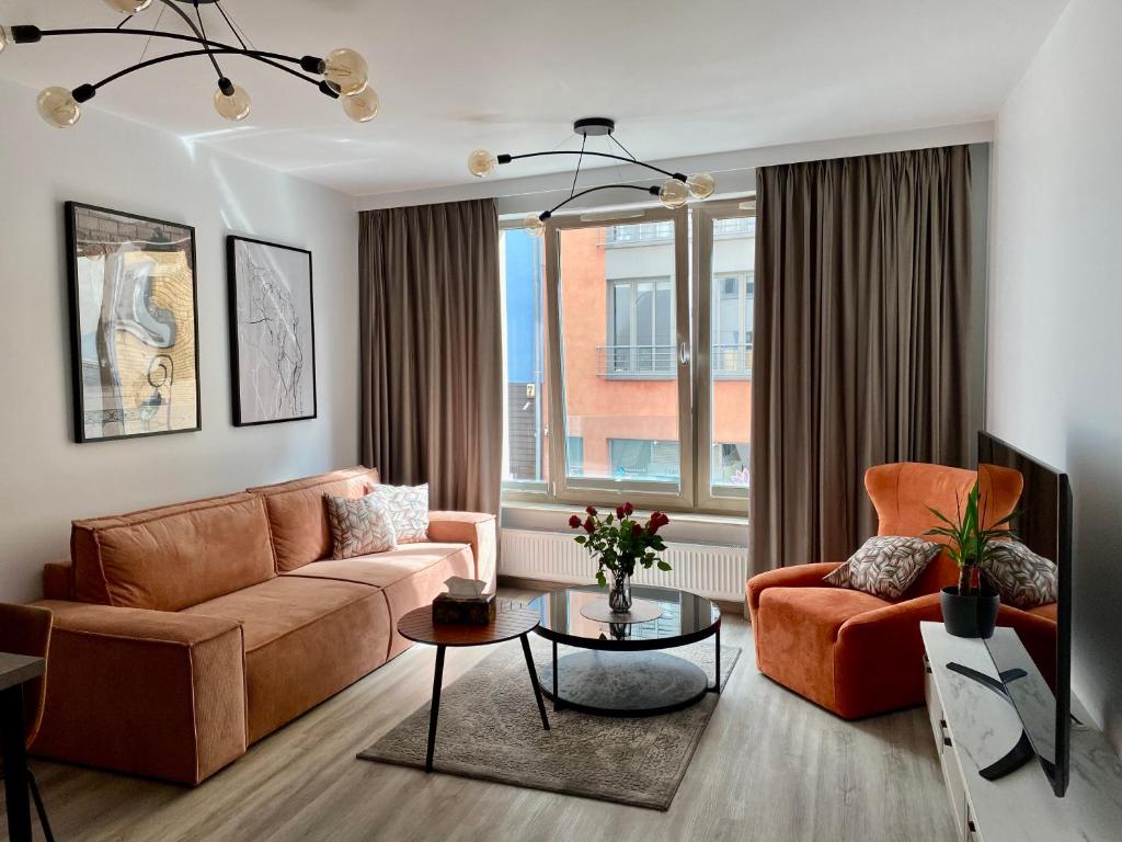 - un salon avec un canapé et deux chaises dans l'établissement Apartament Środowa by Prestige Home, à Szczecin