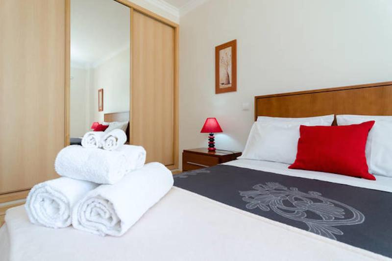 um quarto de hotel com uma cama com toalhas em Cozy Apartment PORTIMÃO City Center em Portimão