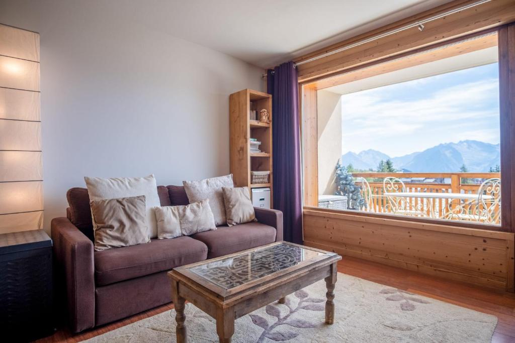 salon z kanapą i dużym oknem w obiekcie Superb apartment with balcony in the heart of Huez - Welkeys w mieście LʼHuez