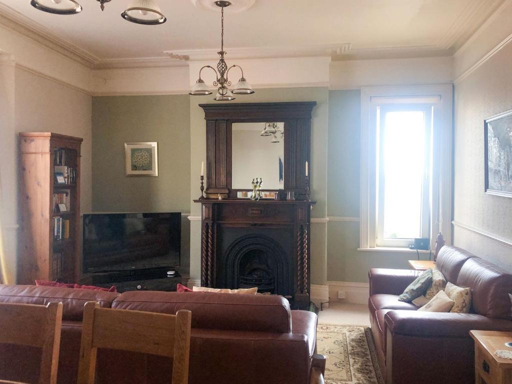 a living room with a couch and a fireplace at Coastal Hideaway in Sandown