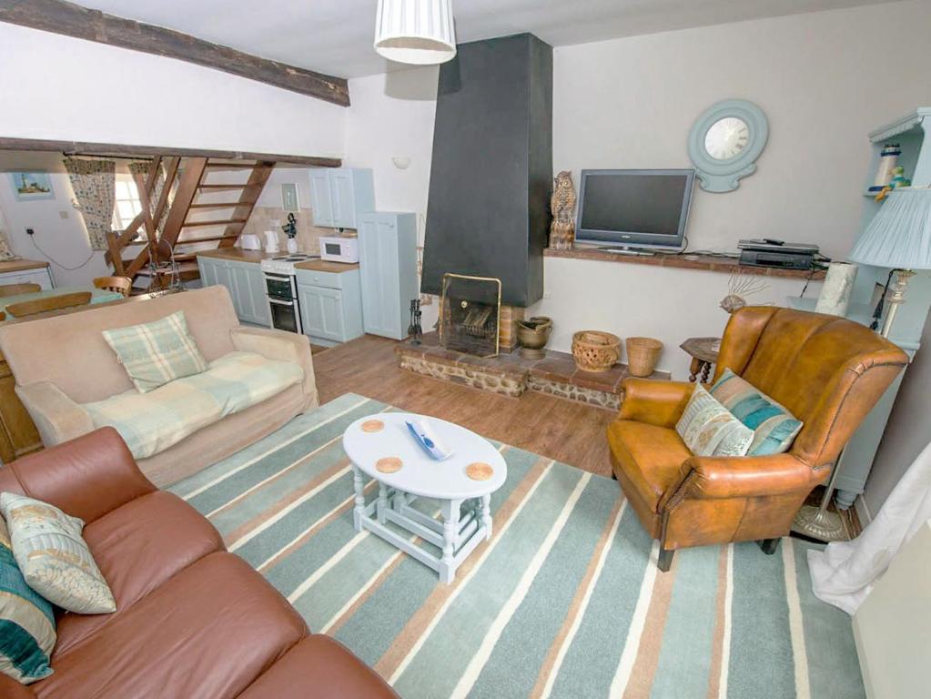 a living room with a couch and chairs and a table at Buttercup Cottage - Ukc2847 in Blakeney