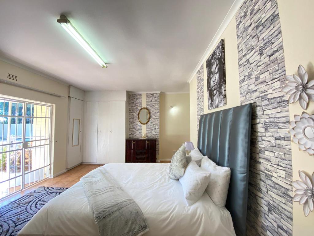 a bedroom with a large bed and a brick wall at MT Perry in Johannesburg