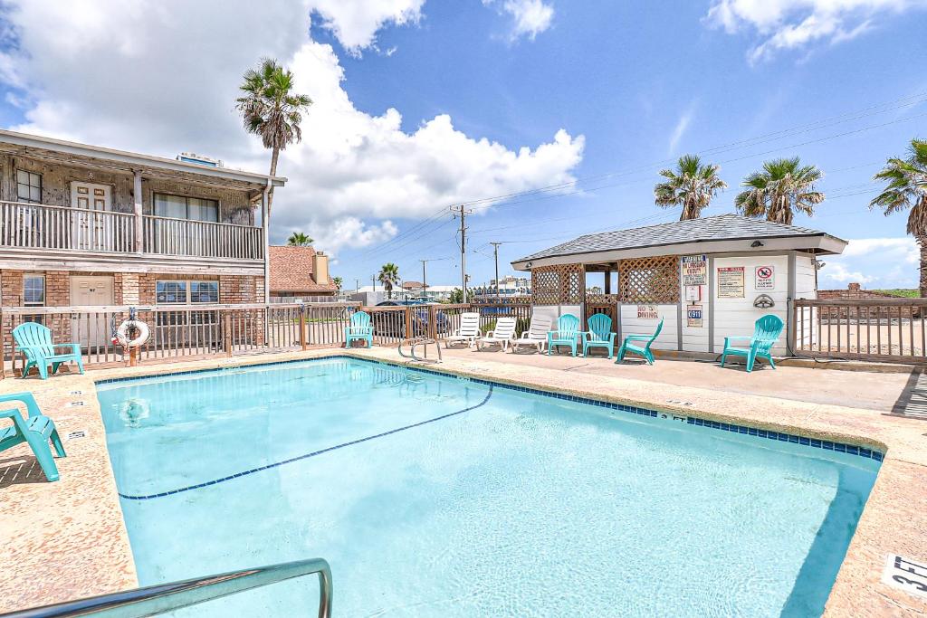 a swimming pool with chairs and a gazebo at Seascape Villas in Padre Island