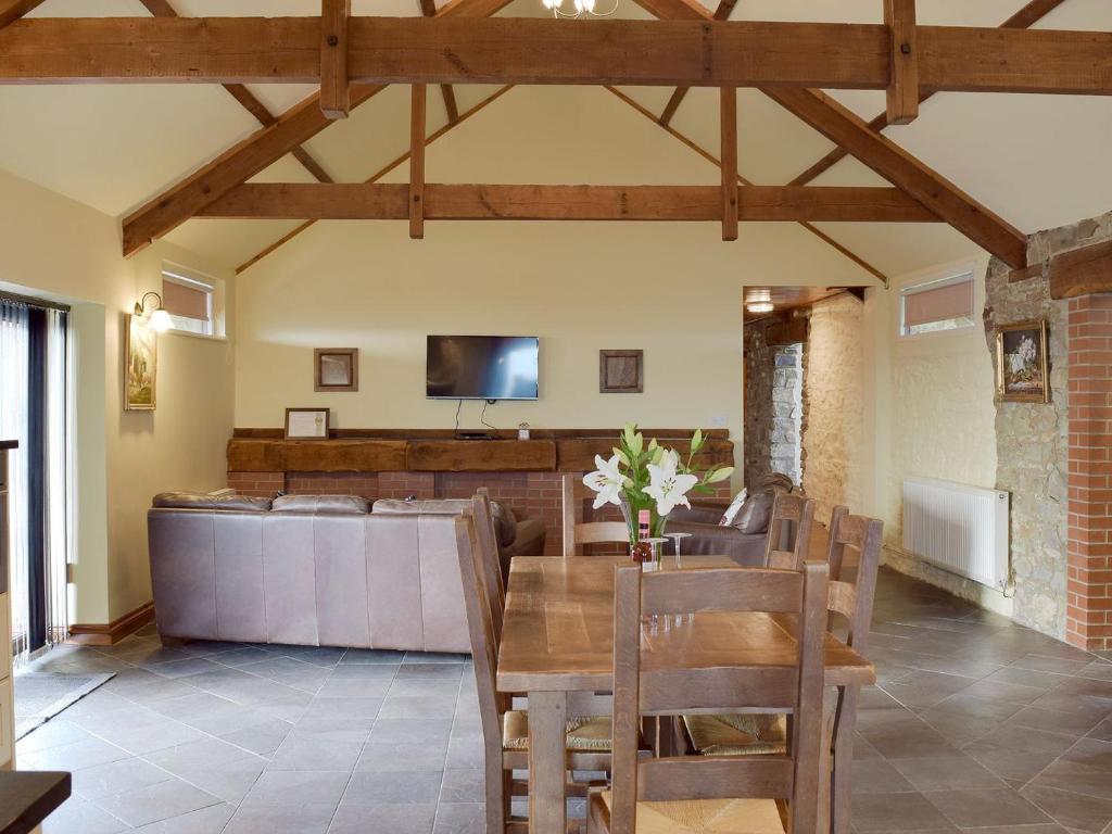 une salle à manger avec une table et une télévision dans l'établissement Elm Cottage-w40630, à Gelliwen