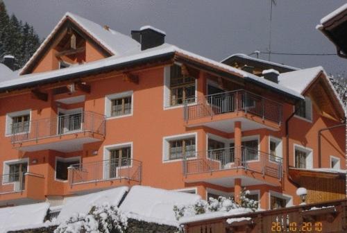 un edificio de apartamentos naranja con nieve. en Appartement beim Brunnen 12, en Sölden