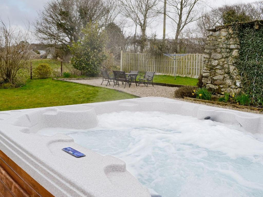 a jacuzzi tub in the backyard of a house at Bwthyn Clyd in Dyffryn