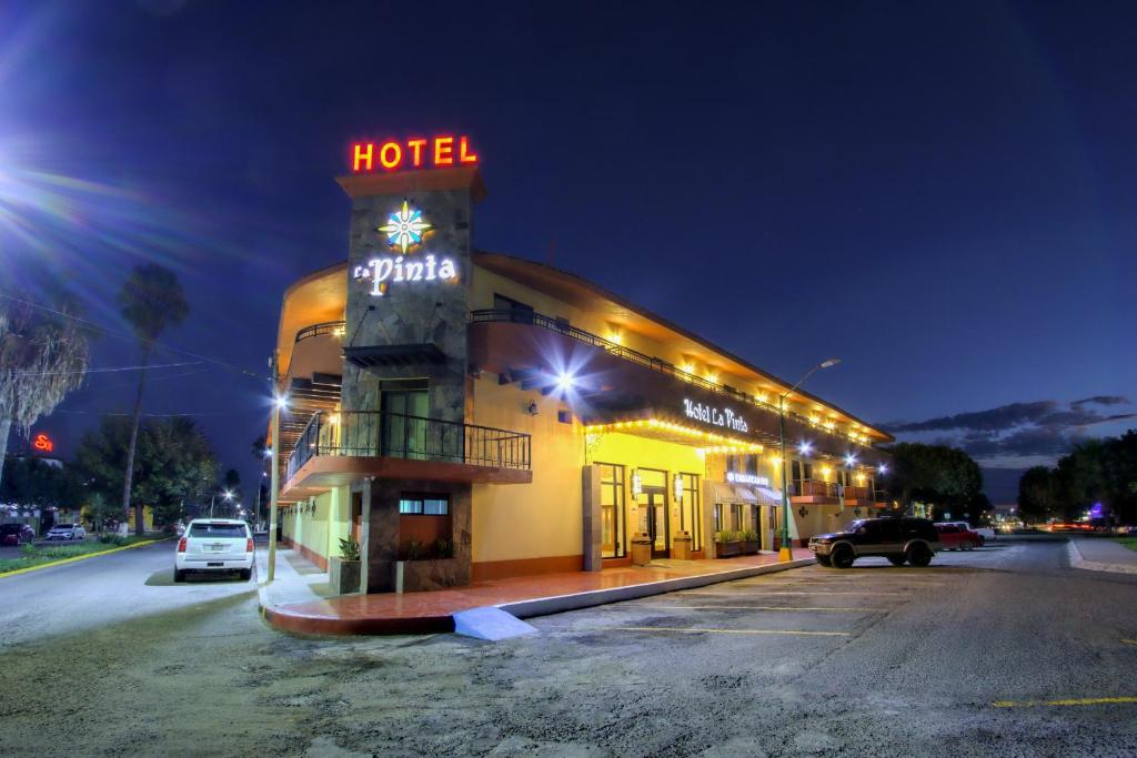 um hotel com uma placa em cima à noite em La Pinta Hotel em Ensenada