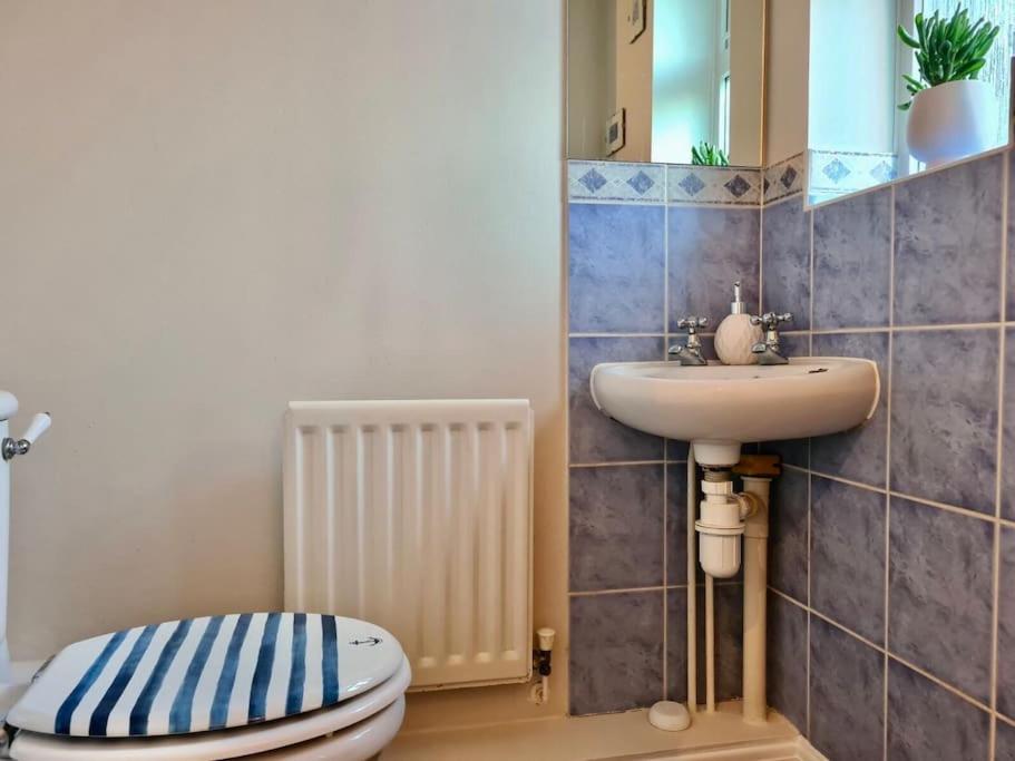 a bathroom with a toilet and a sink at Delight Marvel- Beech Hurst-3 bedroom house in Maidstone