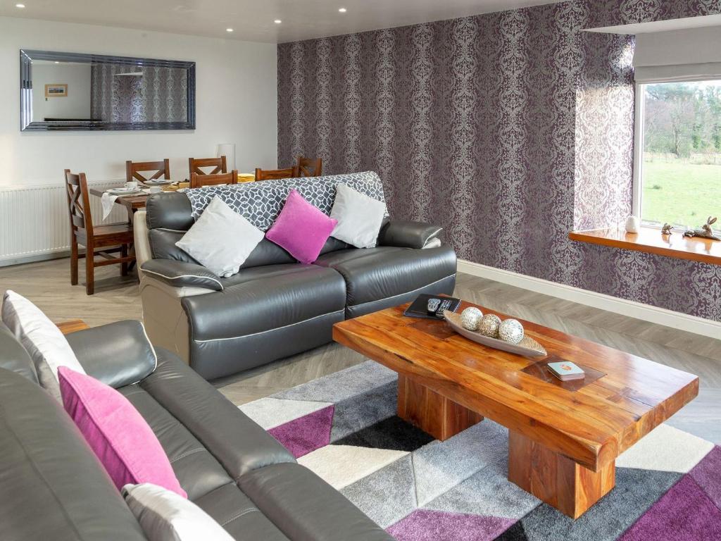 a living room with a couch and a coffee table at Sunset View in Ardmaleish