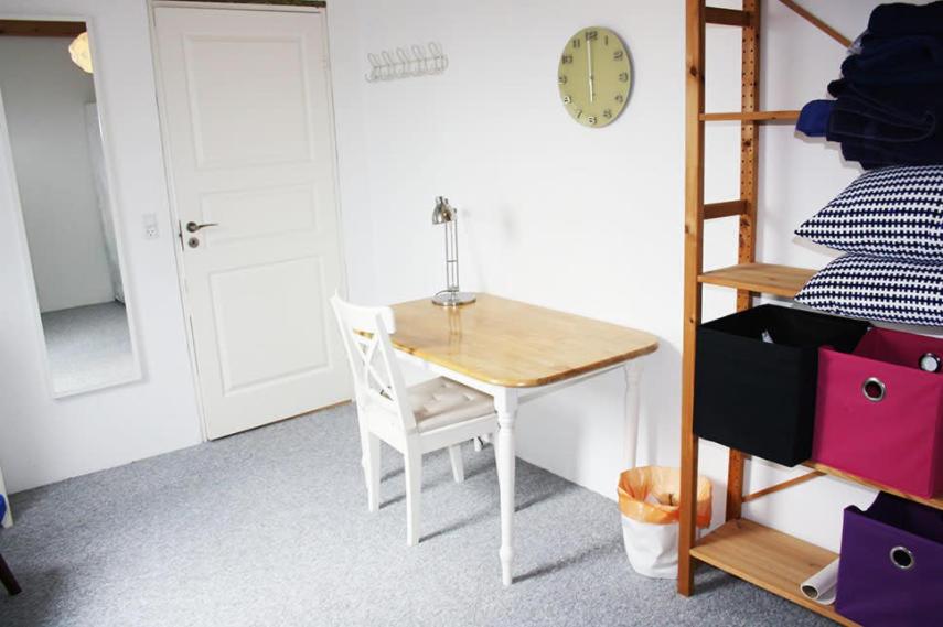 a table and chair in a room with a bunk bed at Dejligt værelse lyst og hyggeligt in Skovlunde