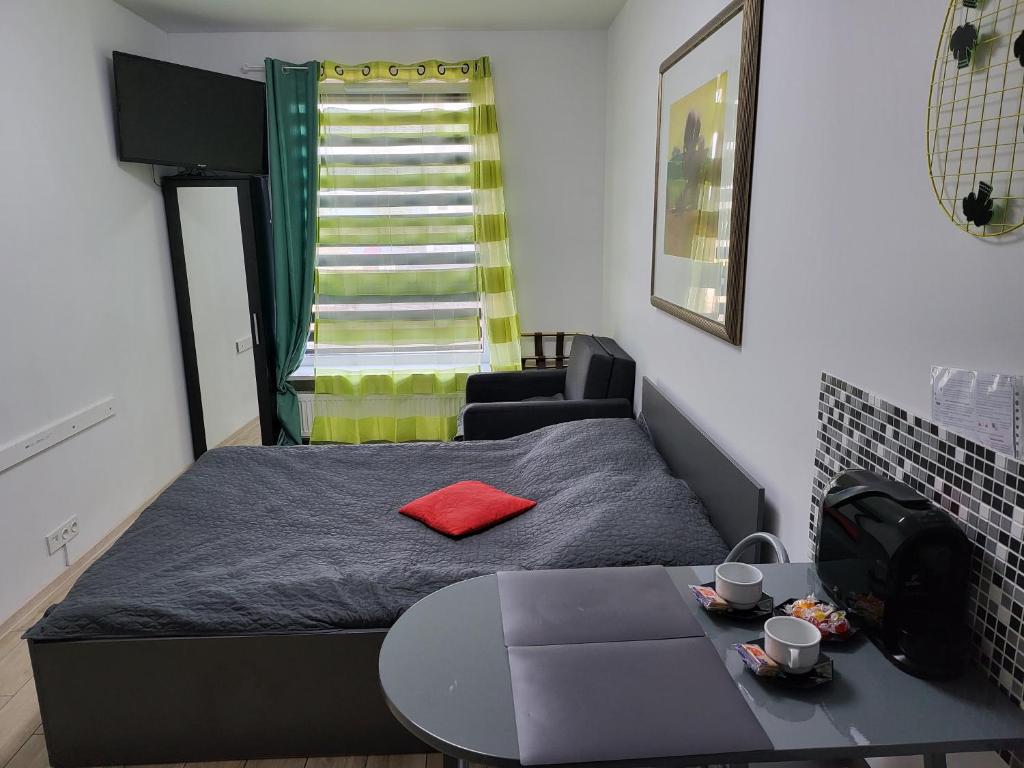 una piccola camera con letto e tavolo di Apartamenty GALERIA PÓŁNOCNA a Varsavia