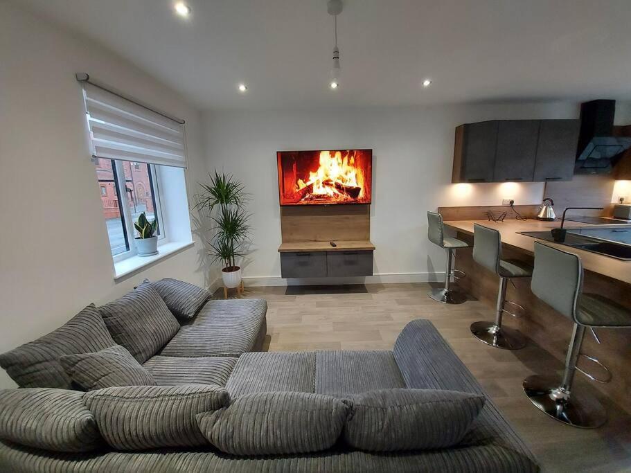 a living room with a couch and a fireplace at Luxury home away from home in Manchester