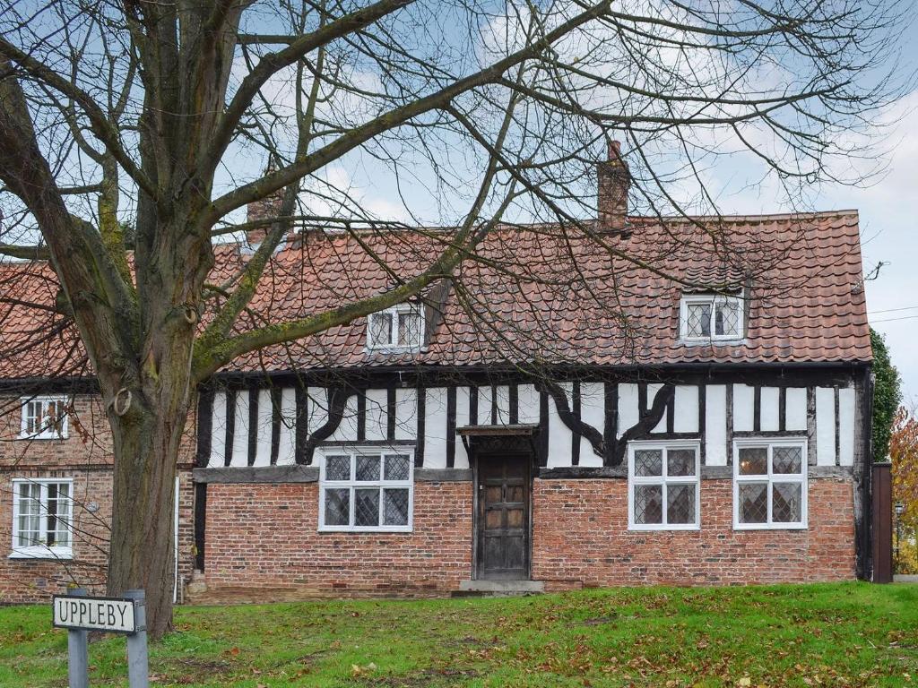 an old brick house with a sign in front of it at Tudor House in Easingwold