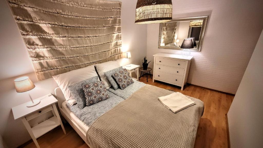 a small bedroom with a bed and a mirror at Apartament DANA piękna plaża wydmy las in Ustka