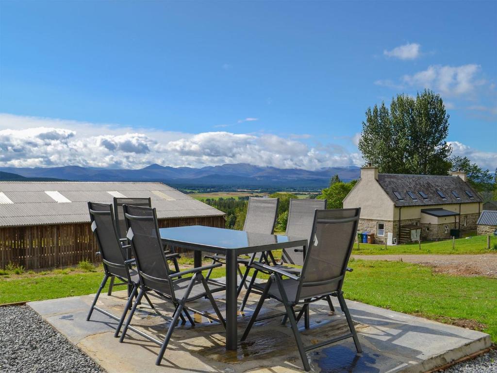une table et des chaises assises sur une terrasse dans l'établissement Wester Laggan Cottage, à Skye of Curr