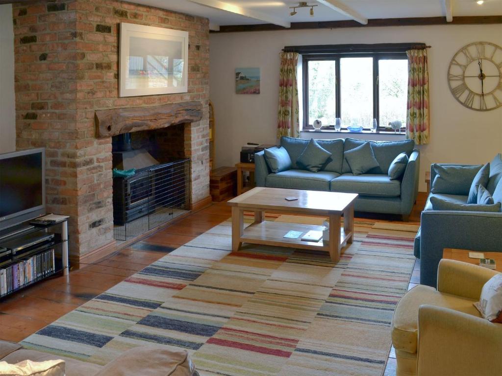 ein Wohnzimmer mit einem Sofa und einem Kamin in der Unterkunft Reubens in Moreleigh