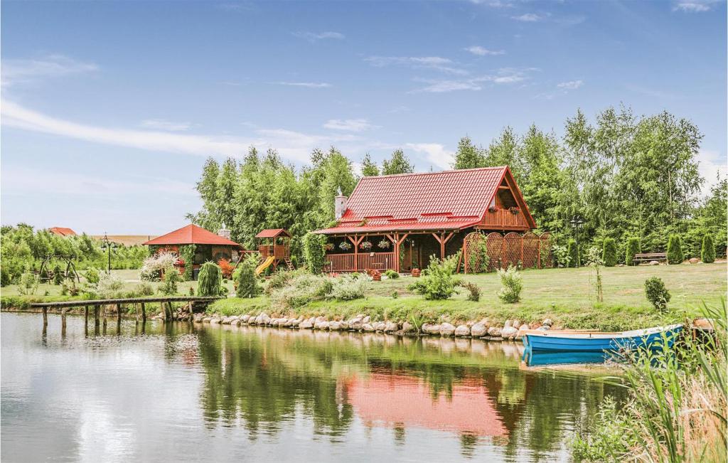 a large wooden house next to a lake at Cozy Home In Wegorzewo With Wifi in Trygort