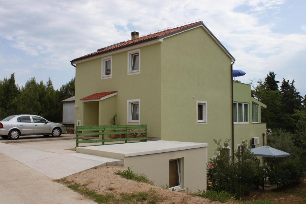 a green house with a bench in front of it at Apartments with a parking space Nerezine, Losinj - 7961 in Nerezine